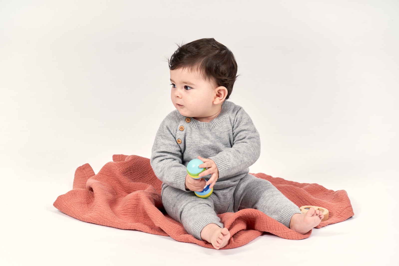 Baby sitzt auf einer kuscheligen Decke