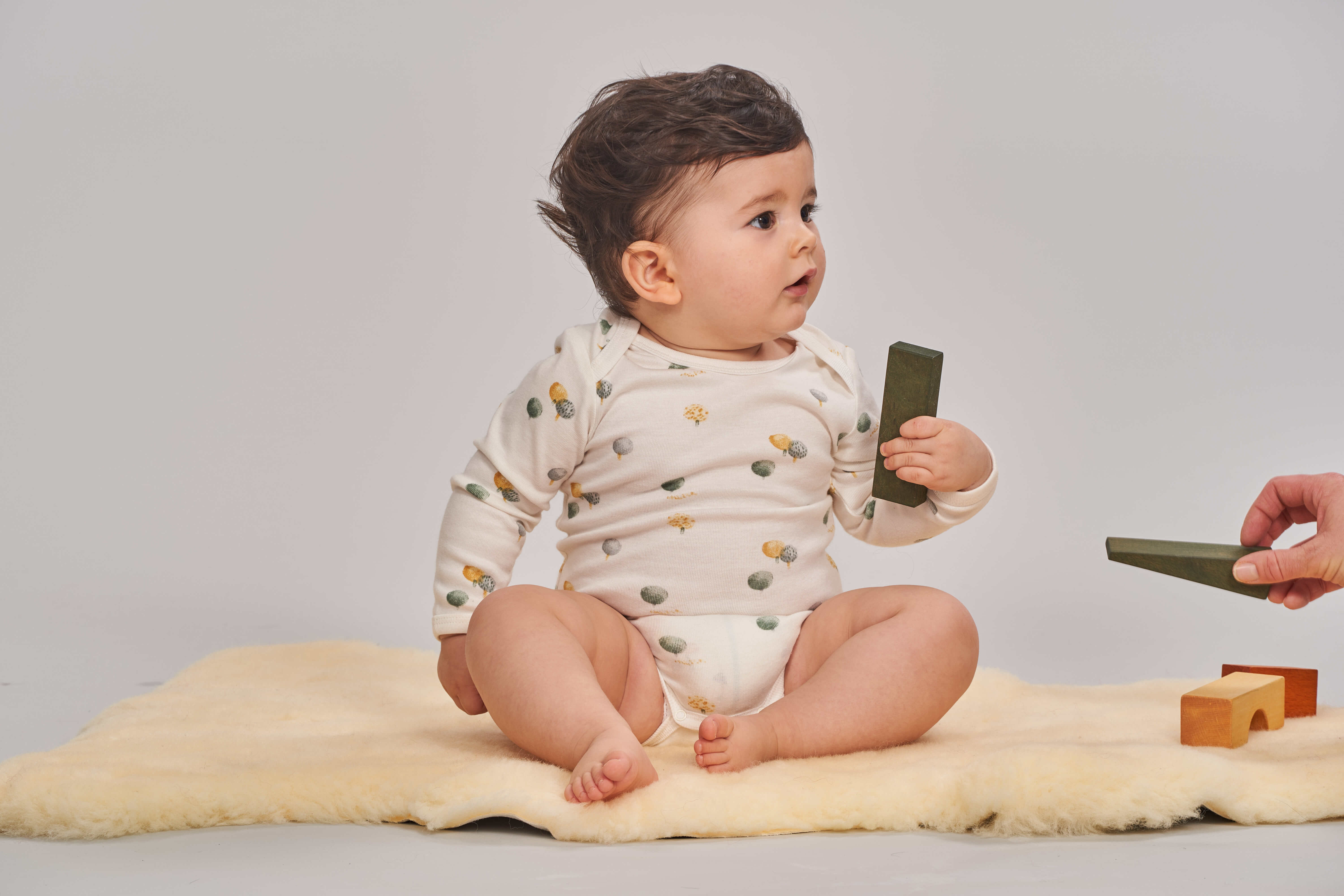 Baby mit Spielkl&ouml;tzen in der Hand